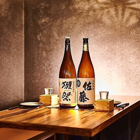 地鶏と土鍋 個室居酒屋 鶏進 姫路駅前店 モダンなテーブル席と獺祭（日本酒）の写真